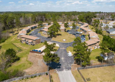 An aerial view of the Cedar Heights community, a loop of townhome-style apartment buildings surrounded by trees