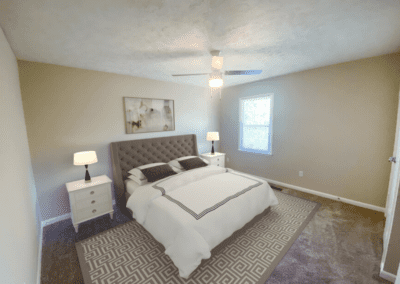 A staged bedroom with carpeted floors and elegant furniture