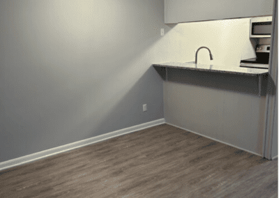 An empty dining room with a view of the kitchen behind an island counter