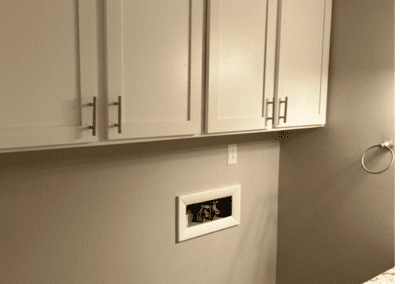 A corner of a bathroom with washer and dryer hookups