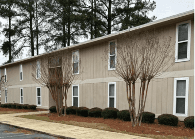 And angled view of a long beige apartment building in the Magnolia Crossing community