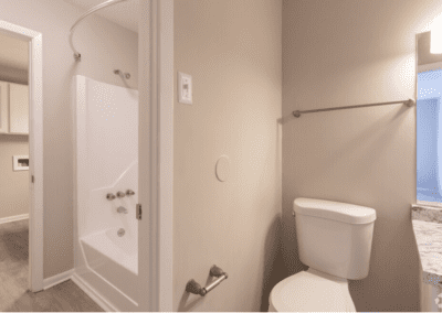 A view of the bathroom. There are three separate spaces for the toilet, shower, and laundry