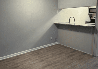 An empty dining room with a view of the kitchen behind an island counter