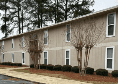 And angled view of a long beige apartment building in the Magnolia Crossing community