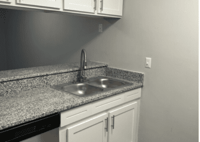 A kitchen with white cabinets and stainless steel appliances