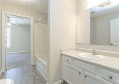 A white bathroom that is connected to the bedroom