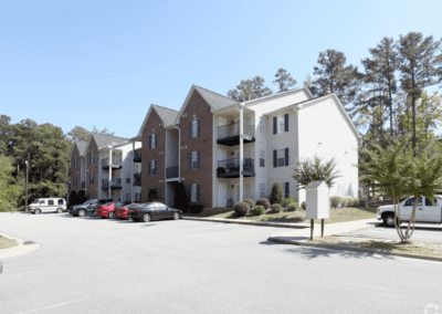 A three-story apartment building with white and brick siding in the Woodland Ridge apartment community