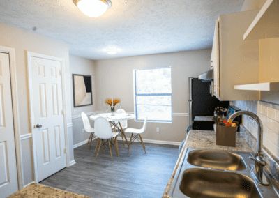 An open kitchen with a dining nook and a large window to let in lots of natural light