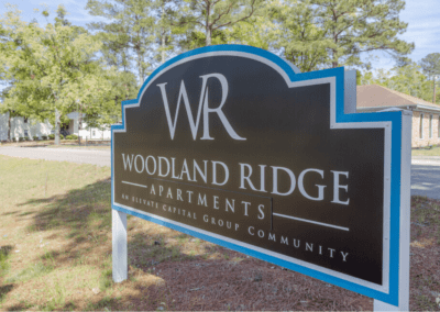 A sign for the Woodland Ridge Apartments, An Elevate Capital Group Community