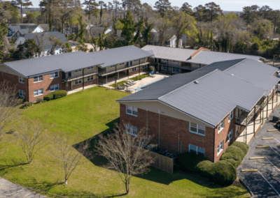 An aerial view of the Oakridge Apartments, a U-shaped building with brick siding and a pool in the middle