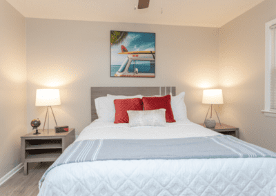 A bedroom staged with a queen-sized bed and two sleek wooden end tables