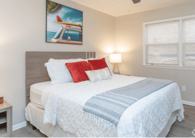 A bedroom staged with a queen-sized bed and two sleek wooden end tables